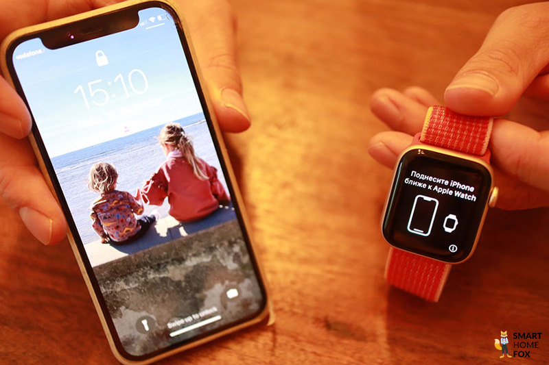 Man sieht die Apple Watch SE neben einem iPhone.